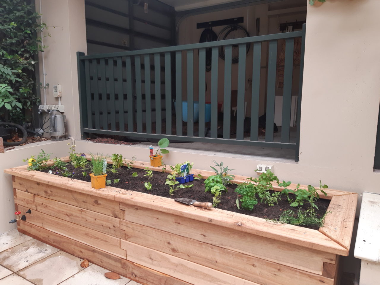 Custom ModBOX raised garden bed in a corner of a courtyard
